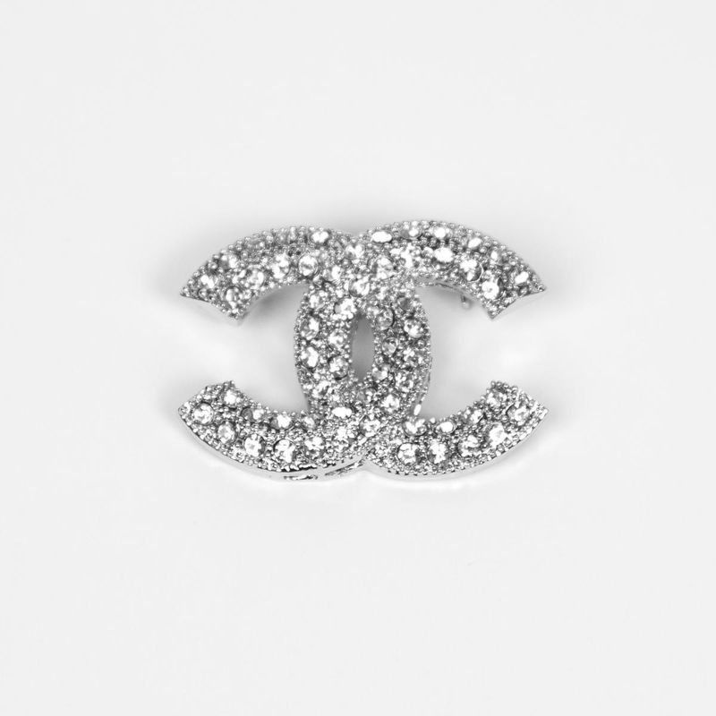 Brosch i silverfärgad metall - dubbel C-form med strass 4 x 3 cm